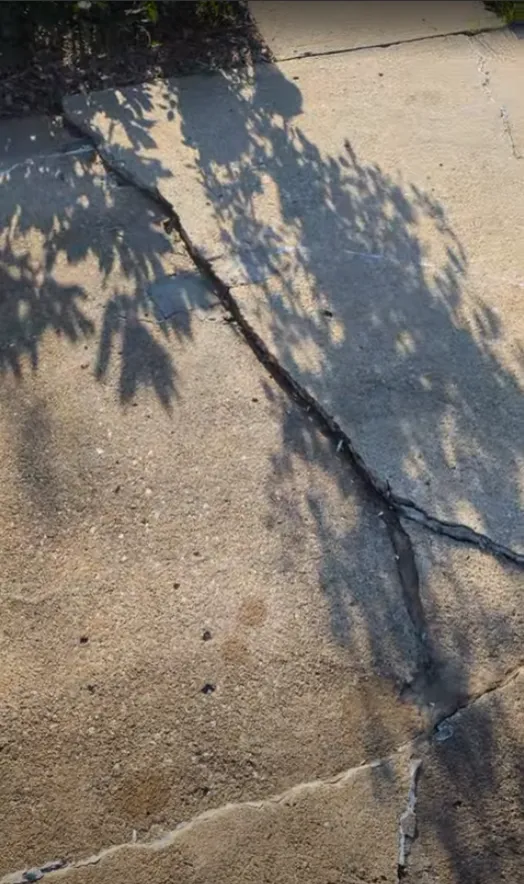 Raised concrete edge and cracking near the garage before correction